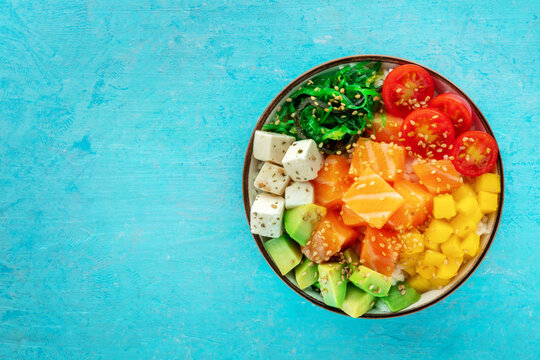 Salmon poke bowl with mango, avocado, tofu, wakame, cherry tomatoes
