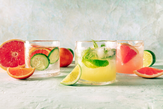 Refreshing summer cocktails with ice cubes on a light background