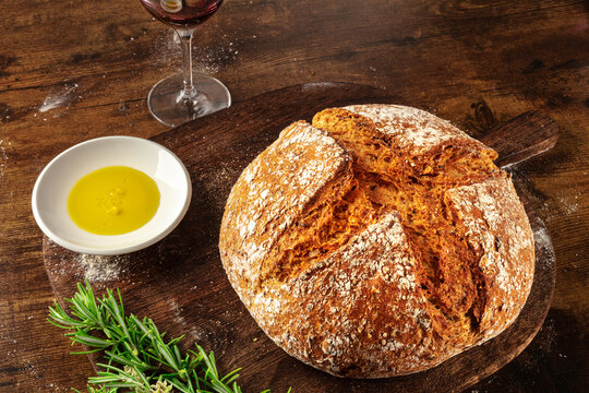 Homemade artisan sourdough bread loaf on a rustic wooden cutting board