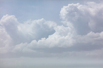Obraz premium Soft white clouds drift against a pale blue sky