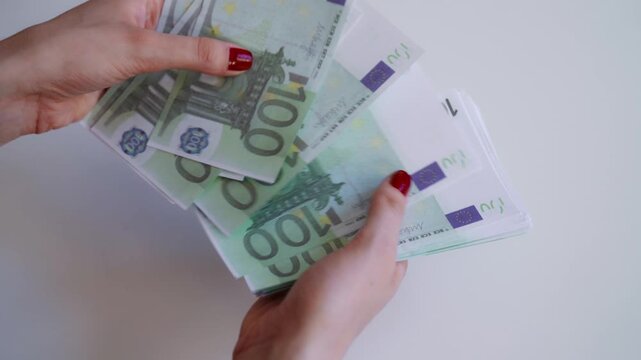 Woman hands counting stack of one hundred euro banknotes.