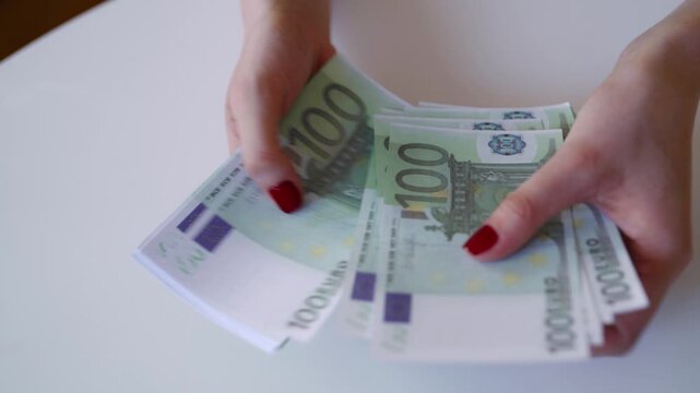Woman hands counting stack of one hundred euro banknotes.