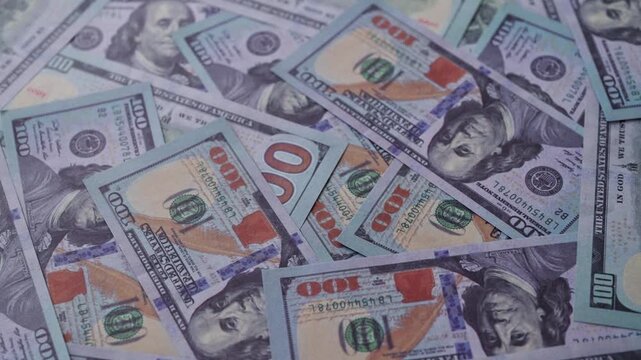 Background of one hundred US dollar bills scattered randomly.