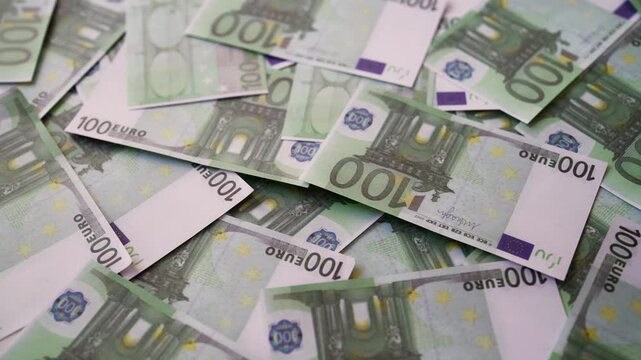 Background of one hundred euro banknotes scattered randomly.