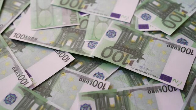 Background of one hundred euro banknotes scattered randomly.