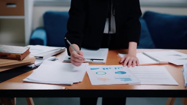 Business Audit Professional Reviewing Financial Charts and Reports with Pencil at Office Desk