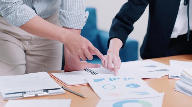 Business Colleagues Reviewing Financial Charts and Reports on Office Desk During Meeting