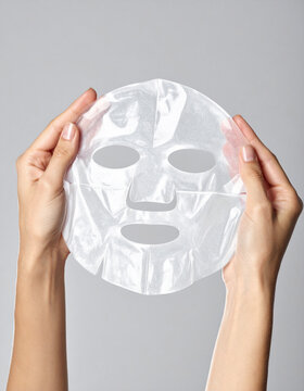 ハイドロゲルフェイスマスクを持つ手元、透明感のある保湿スキンケア素材 / Hands holding hydrogel face mask, translucent moisturizing skincare material