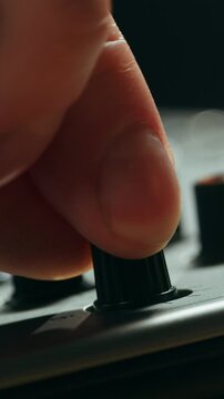 Music studio close up, Close up hands shot of sound engineer using mixing console, remote control for adjusting sound, audio mixer. Musician creates music, makes remix for DJ set. Sound