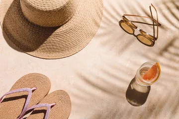 A straw hat, sunglasses, flip-flops, and a refreshing cocktail sit on a sunlit poolside surface with palm shadows, tropical vacation vibe, resort relaxation, luxury lifestyle, summer getaway. © magic_cinema