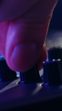 Music studio close up, Close up hands shot of sound engineer using mixing console, remote control for adjusting sound, audio mixer. Musician creates music, makes remix for DJ set. Sound