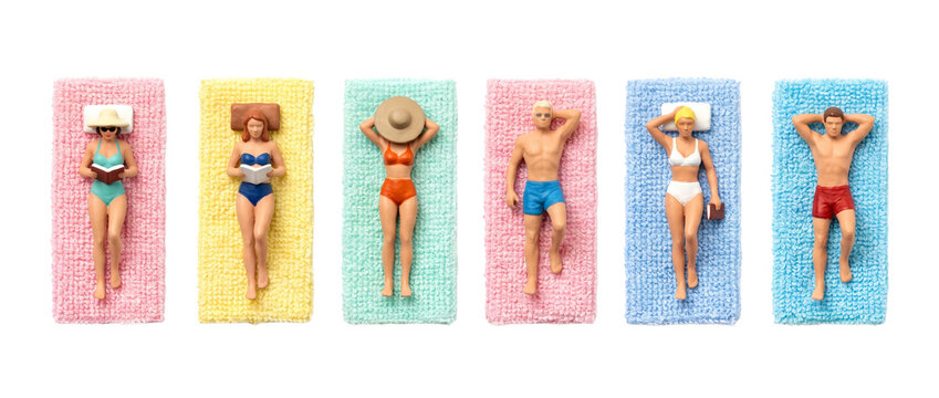 Miniature people sunbathing beach towels in a row, tiny figurines relaxing on colorful mats, summer holiday concept, top down view flat lay of micro toy vacationers on black background.