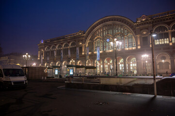 Fototapeta premium Turin, piedmont, italy. November 20, 2024. Turin porta nuova railway station building illuminated at night. Historic architecture with arches and glass reflecting city lights