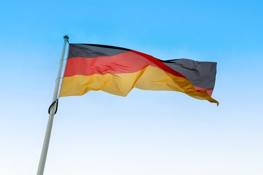 Germany national flag waving proudly against clear blue sky