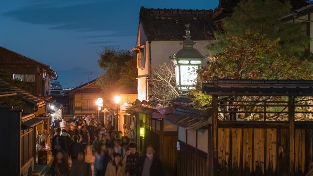 Timelapse of tourists exploring the historic Gion district at dusk in Kyoto, Japan.  