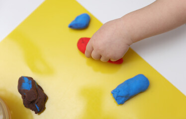 Little baby plays with plasticine. Children's creativity. Motor skills development. © splitov27