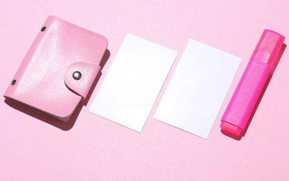 Business card holder with white blank business cards and pen on pink background