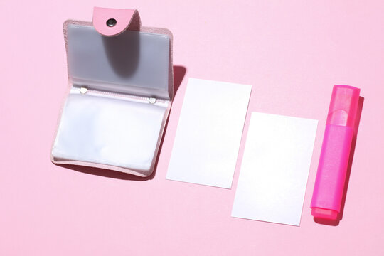 Business card holder with white blank business cards and pen on pink background