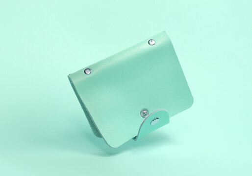 Blue leather business card holder floating on a blue background