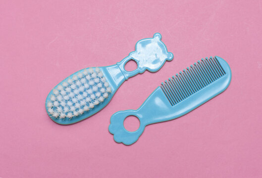 Combs and hairbrush for newborn on pink background