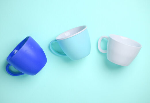 Three ceramic cups on a blue background