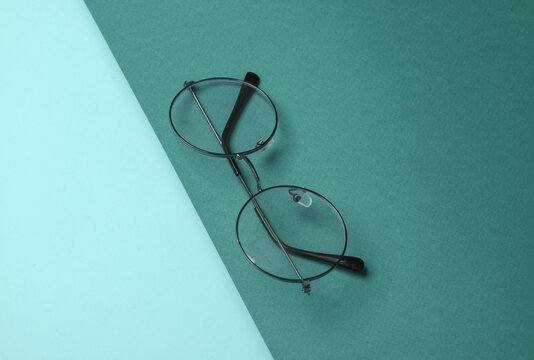 Stylish eyeglasses on green background