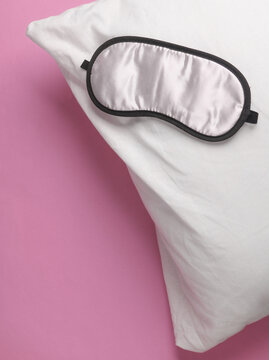 Sleeping mask with pillow on a pink background. Healthy sleep concept