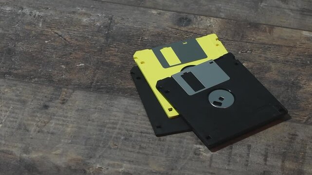 View of floppy disks in a hand with a wooden background showing their details