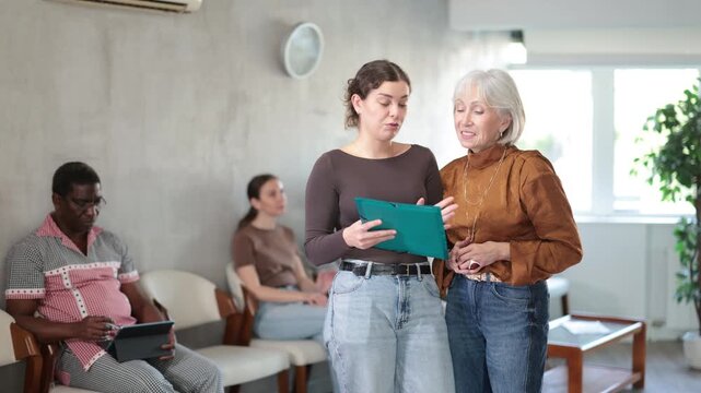 Office worker explains legal documents to an elderly woman. High quality 4k footage