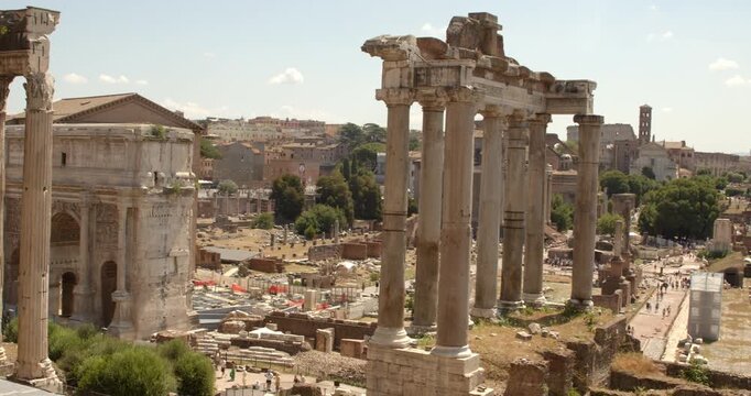 Panorama of Imperial Fora in Rome, Italy. A breathtaking view of the Temple of Saturn columns and the Arch of Septimius Severus in the Roman Forum. It's a sunny summer day on the Italian capital.