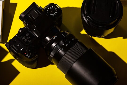 Close-up of black binoculars on yellow background
