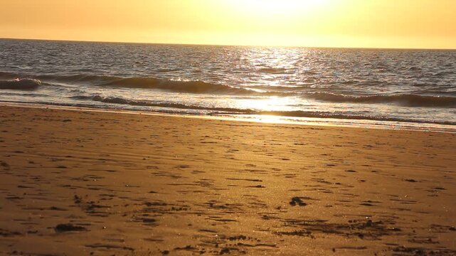 Dramatic evening red sky with the sun rays crossing the clouds. Harmony of meditation near the beautiful sea waves of Normandie and Bretagne. The golden and blue hour of the sunset.
