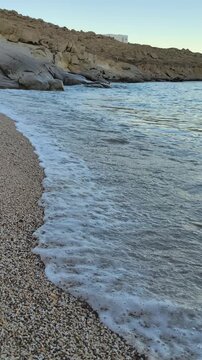Calm waves at sunset at Lia Beach on Mykonos Island in Greece
