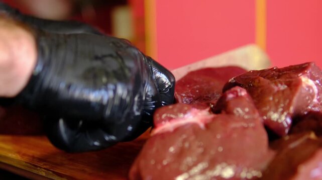 to cut beef liver. Uncooked beef liver on a wooden surface. 