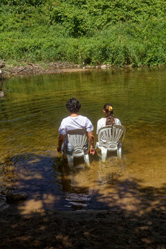 La maman et sa fille assise sur une chaise dans le lit de la rivi&egrave;re