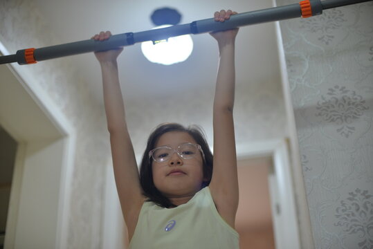 Young Girl Exercising on Indoor Pull Up Bar