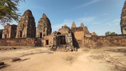 Obraz premium Ancient sandstone temple ruins inside Angkor Archaeological Park in Siem Reap, Cambodia. Historic Khmer architecture surrounded by tropical scenery, one of Southeast Asia's most iconic UNESCO World He