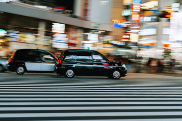 Tokyo taxis crossing pedestrian crosswalk at night in Shinjuku, Japan © MatT