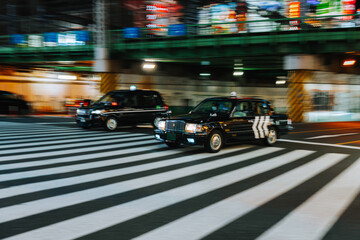Tokyo taxis crossing pedestrian crosswalk at night in Shinjuku, Japan © MatT