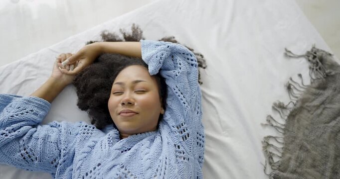 Portrait of young American black woman lying peacefully in bed with eyes closed, enjoy restful sleep, relaxation, comfort healthy morning wellness routine.