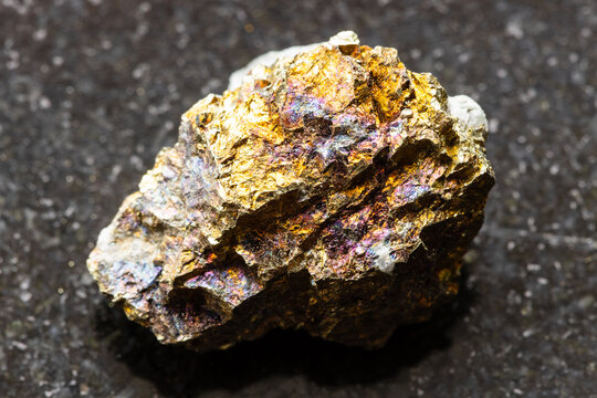 natural chalcopyrite rock closeup on black granite