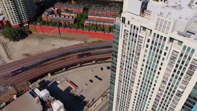 Train passing alongside Left Bank at K Station residential tower in Chicago Fulton River District, typical american metropolis transportation system