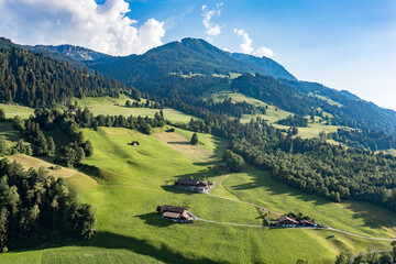 Aerial view of lush alpine pastures and scattered chalets in Erlenbach im Simmental - Canton of Bern, Switzerland © Carismarkus