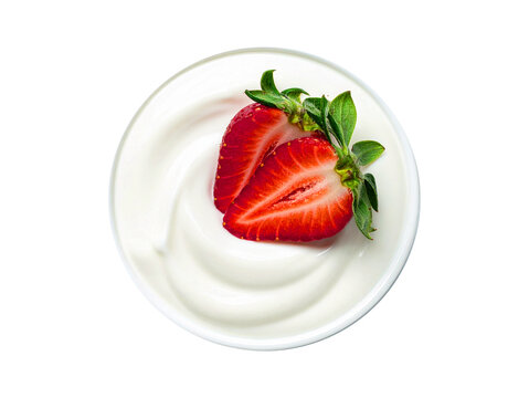 A close-up overhead view of a bowl of white yogurt topped with two halved strawberries and green leaves.