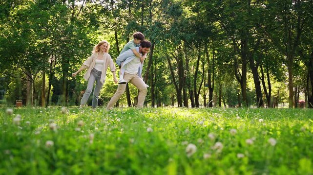 Joyful family enjoys active outdoor fun running through park