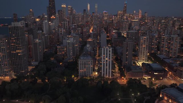 Chicago downtown skyline at twilight with prominent landmarks including Willis Tower, Aon Center, John Hancock Center, St Regis Tower overlooking Lincoln Park