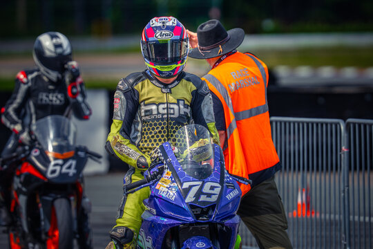 Regular training in Riga, Latvia, Bikernieki on 12-05-2026  Motorcycle racer adjusting helmet at pit stop