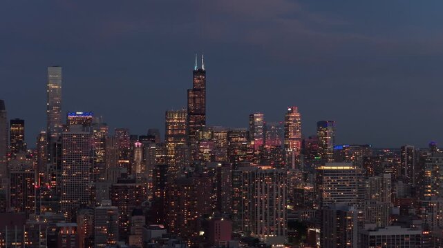 Luminous Chicago skyline featuring iconic Willis Tower and Old Town neighborhood architecture during blue hour over metropolis cityscape and urban financial district