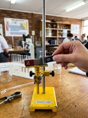 Fototapeta premium Student conducting a science experiment with a magnet in a classroom.