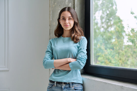 Calm teen girl with crossed arms looking at camera